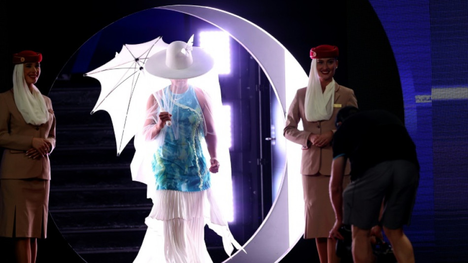 Osaka emerges for Melbourne opener under white hat and umbrella